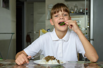 Happy little girl happily eating fresh herbs at lunch