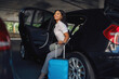 © Nomad_Soul - Woman with suitcase gets into the car on parking