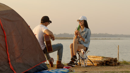 Couple at campsite after make tent playing guitar and sing together