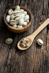 Wall Mural - Pistachio nut in wooden bowl on rusty wood table background