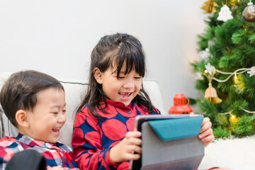 Sticker - Asian kids sibling sister brother video call in christmas holidays celebrate at home.Online video call zoom.Kids watching video with tablet.New normal.Covid-19 coronavirus.Social distancing.stay home.