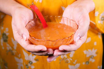 women hand holding a bowl of thai hot spicy soup 