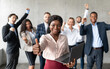 © Prostock-studio - African Businesswoman Gesturing Thumbs-Up Standing With Colleagues In Office