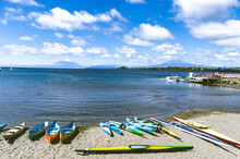 Large Beautiful Blue Lake With Boats And The Osorno Volcano Blurred In The Background.