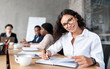 © Prostock-studio - Cheerful Latin Businesswoman At Corporate Meeting Posing Sitting In Office