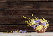 Spring Flowers In Basket On Wooden Background