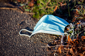 Wall Mural - Used medical face masks on ground on the street. Environmental pollution concept