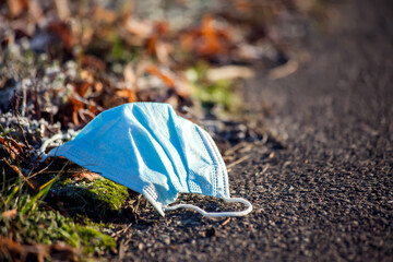 Wall Mural - Used medical face masks on ground on the street. Environmental pollution concept