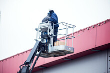 High-altitude Works. Professional Installation Work On A Construction Building Site. Assemblers Perform High-altitude Installation Works On The Lifts Platforms.