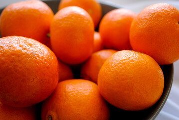 Wall Mural - Ripe juicy tangerines in a deep ceramic plate.