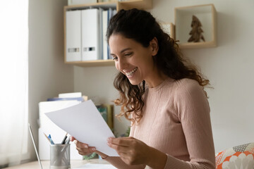 Close up smiling woman reading letter, holding paper sheet, working with correspondence, happy businesswoman or student received good news, money refund or great exam results, domestic bills