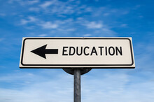 Education Road Sign, Arrow On Blue Sky Background. One Way Blank Road Sign With Copy Space. Arrow On A Pole Pointing In One Direction.