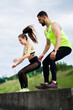 © Georgii - Athletic fit couple jumping, training outdoors, sports pair exercising in urban together