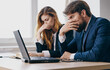 © SHOTPRIME STUDIO - Business men and woman sit at a work table in front of laptop emotions office