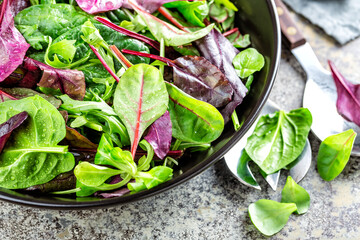 Wall Mural - Salad bowl, healthy food. Fresh salad mix of baby spinach, arugula leaves, basil, chard and lambs lettuce.