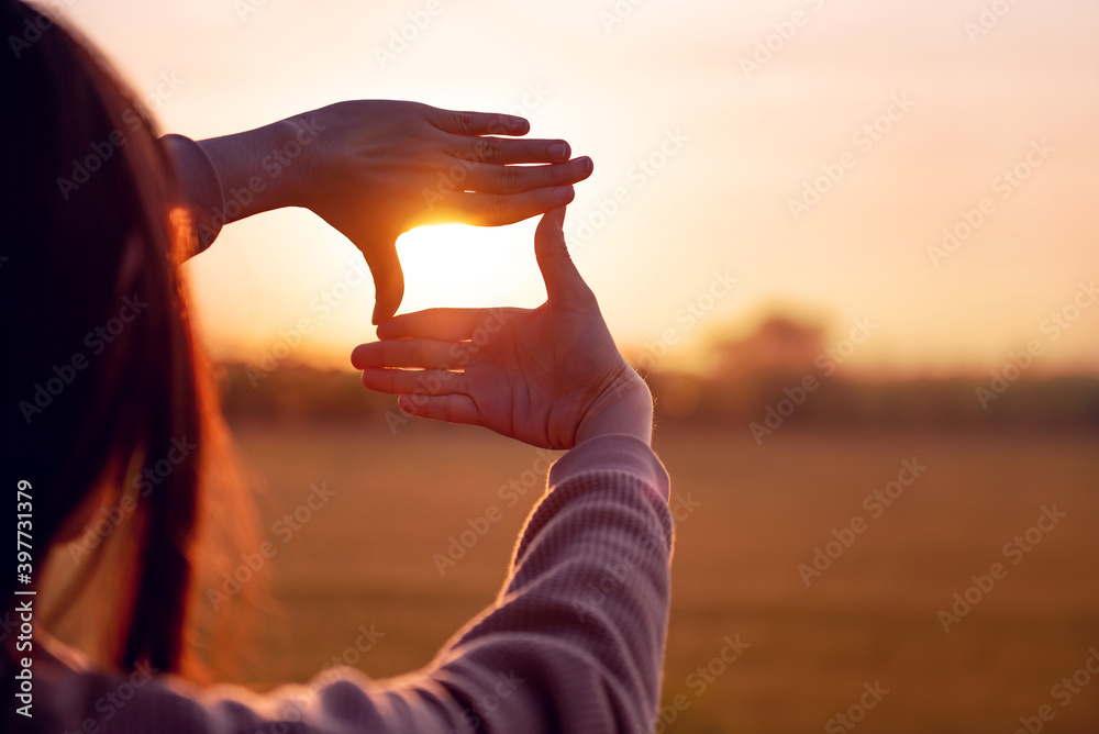 Future planning concept, Close up of woman hands making frame gesture with sunset, Female capturing the sunrise. - obrazy, fototapety, plakaty 