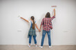 Young couple painting walls and holding hands