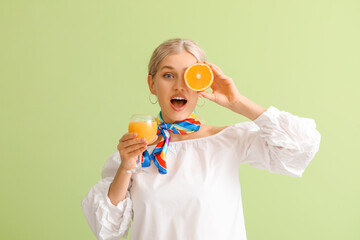 Poster - Beautiful young woman with orange juice on color background