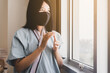 Asian women patient applauding to support people fighting coronavirus through hospital window