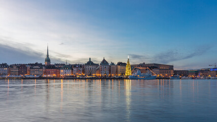 Wall Mural - Stockholm city skyline of Gamla Stan (old city) at dusk with Christmas tree beside the harbor