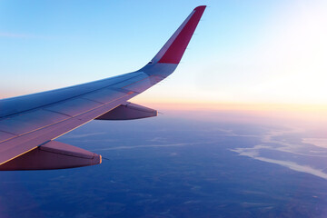 Wall Mural - plane flying above the clouds. View from the wing of the plane. Travel concept