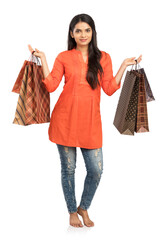 Wall Mural - Pretty Indian young woman with shopping bags on white.