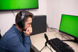 © FarukPhotography - a stressed businessman wears headphones and has an online meeting in his office. a young caucasian businessman wearing a blue shirt in his office