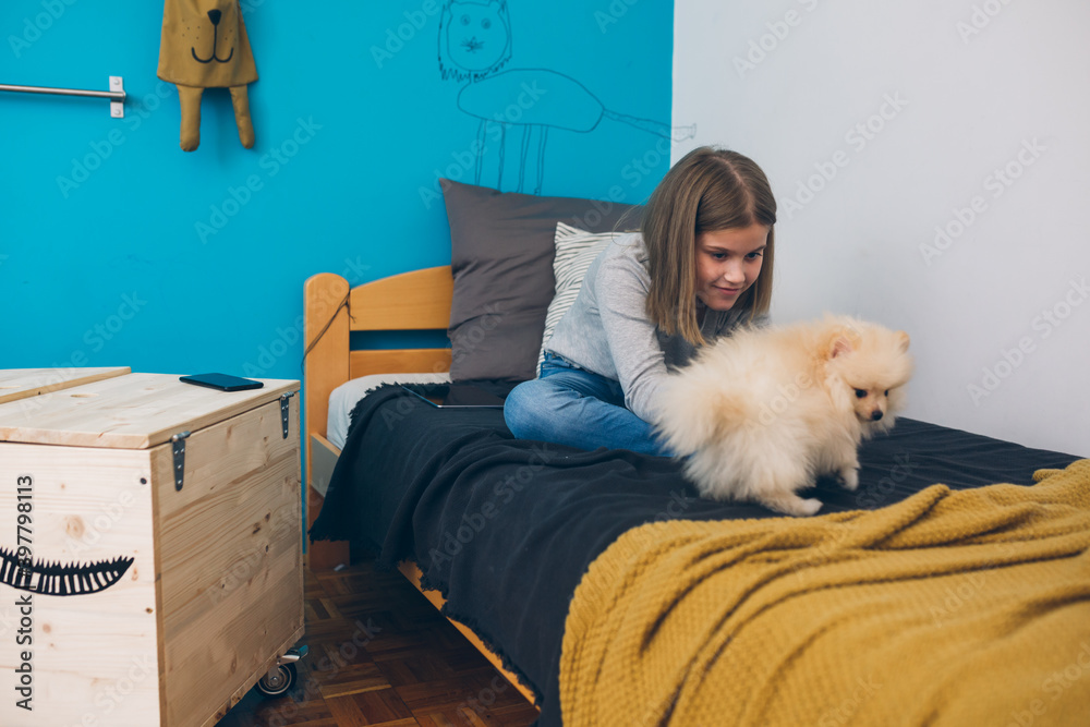 teenager girl relaxing in her room with her dog