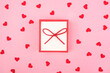 Gift box on a pink background with hearts. View from above. Valentine's day festive concept.