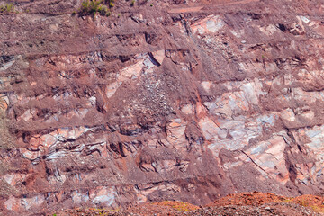 Close-up of red mining levels at iron ore quarry. Open-cast mine, open pit. Background, texture