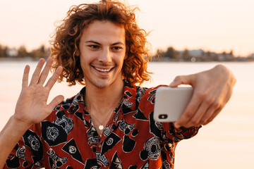 Happy young man taking a selfie while standing