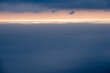 surface de mer bleu gris avec une ligne horizontale de lumière à l'horizon sous des nuages gris bleus 