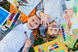 © Iryna - Girl and boy are drawing and painting in the park. They use their imagination and creativity in art. Learning ideas outside the classroom. Top view.