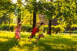 © Comeback Images - Group of three children having fun playing tag game in sunny summer park. Little friends running on green grass, chasing each other and trying to touch