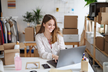 Young woman dropshipper with laptop working at home, coronavirus concept.