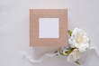 © IndrePau - Wedding favor box and sticker mockup, blank square tag , card or sticker on gift box for design presentation, top view.