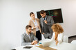 © BGStock72 - Group of young business people working and communicating while sitting at the office desk together