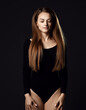 © Dmitry Lobanov - Young beautiful woman with long silky straight hair in black body with eyes closed standing and posing over dark background. Haircare, beauty, wellness concept