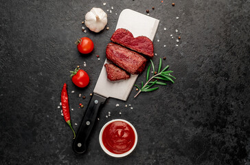 Wall Mural - Different degrees of roasting heart shaped beef steak with spices on a meat knife on a stone background with copy space for your text