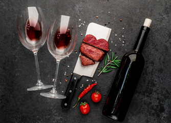 Wall Mural - Dinner for two. Three pieces of meat. three types of grilled meats: rare, medium, well-done heart-shaped, bottle of wine and wine glasses on a stone background