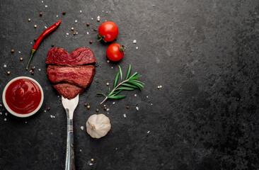 Wall Mural - Different degrees of roasting beef steak in heart shape with spices on a meat fork on a stone background with a copy of the space for your text