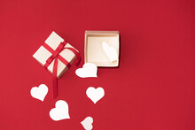 White Gift Box With Red Ribbon And White Hearts On Red Background. Concept Of Valentins Day, Copy Space And Mock Up