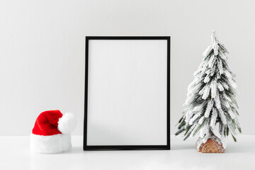 Christmas holiday composition. Xmas tree, Santa hat, photo frame, decoration on white background. Christmas, New Year, winter concept. Front view, copy space