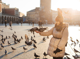 Canvas Print - Young woman and pigeons in Market Square, Krakow, Poland