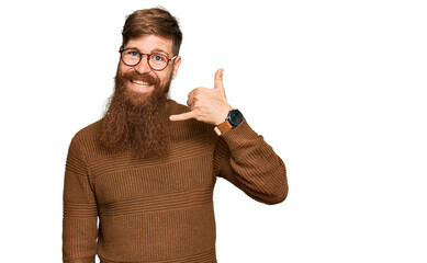 Canvas Print - Young irish redhead man wearing casual clothes and glasses smiling doing phone gesture with hand and fingers like talking on the telephone. communicating concepts.