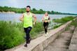 © Georgii - Athletic couple jogging in stylish sportswear, pair training outdoor, sport and healthy lifestyle