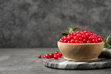 Tasty ripe cranberries on grey table, closeup. Space for text