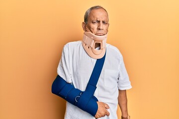 Canvas Print - Handsome mature senior man wearing cervical collar and arm on sling depressed and worry for distress, crying angry and afraid. sad expression.