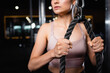 © LIGHTFIELD STUDIOS - cropped view of sportswoman training triceps on cable pushdown machine on blurred background