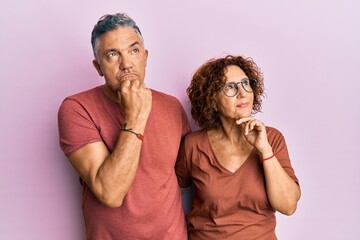 Poster - Beautiful middle age couple together wearing casual clothes with hand on chin thinking about question, pensive expression. smiling with thoughtful face. doubt concept.